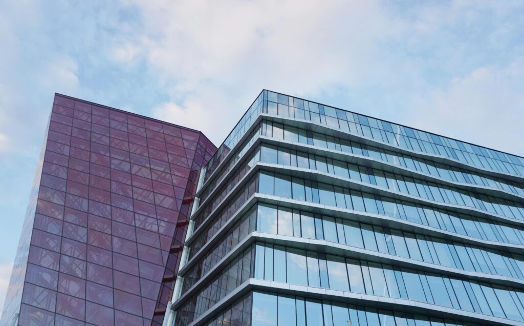 pexels-photo-210726-210726 Contemporary urban architecture with glass and red facade against blue sky.